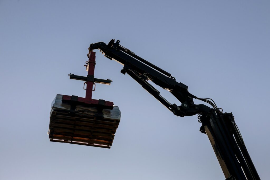 Cranes lifter building materials to the building with crane truck in the roof of the builders