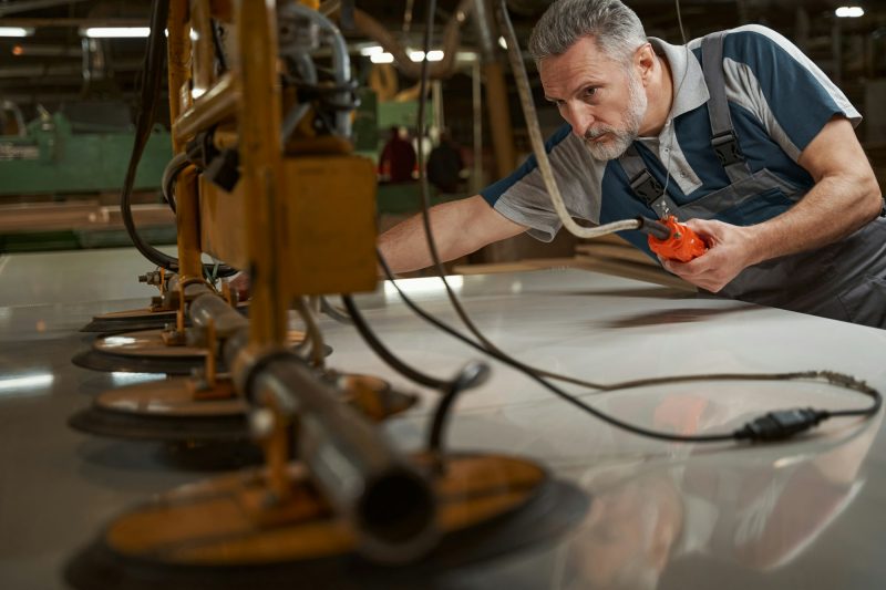 Close up of bearded man checking the woodworking machine